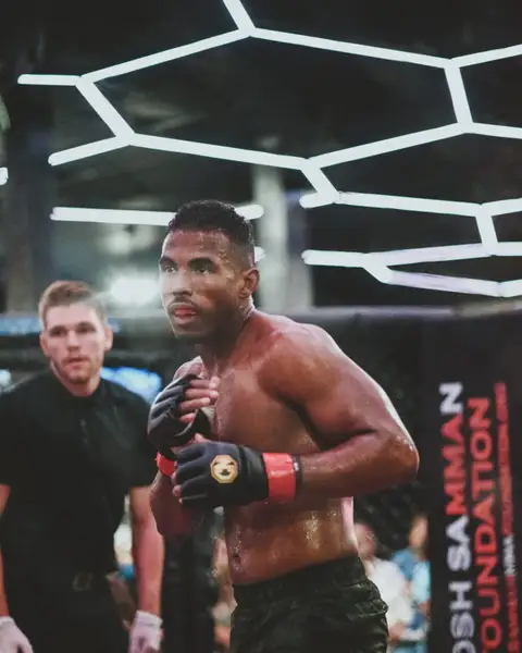 Shaquille van Zichem in the MMA cage, wearing fight gloves